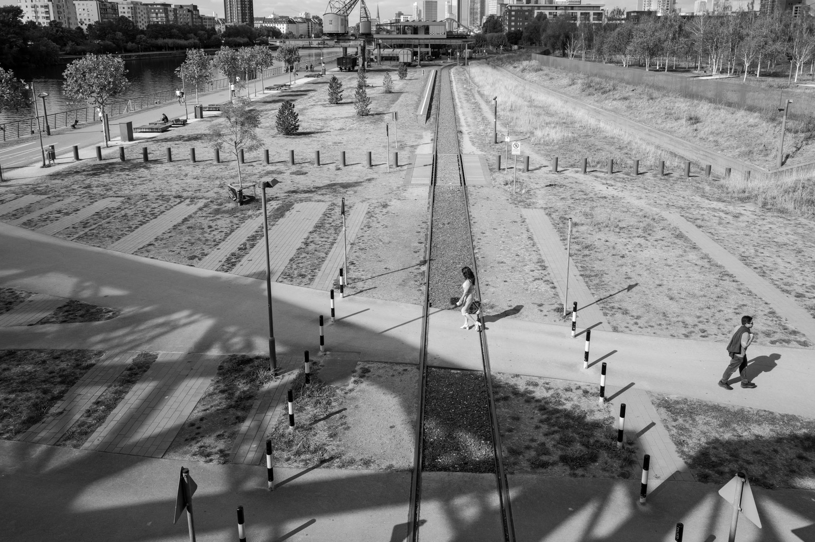 Allee diagonale traversant un parc en pente, promeneurs au loin, Francfort