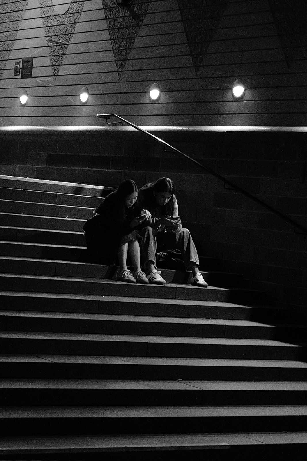 Groupe assis sur des marches illuminees la nuit, Francfort