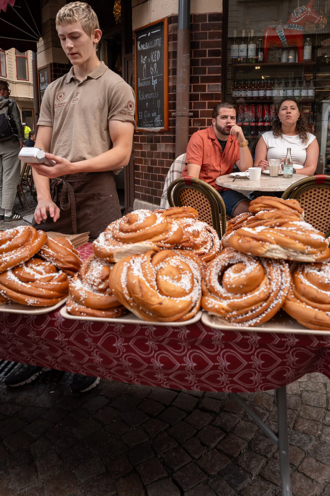A waiter behind a table covered with giant cinnamon buns, Gothenburg