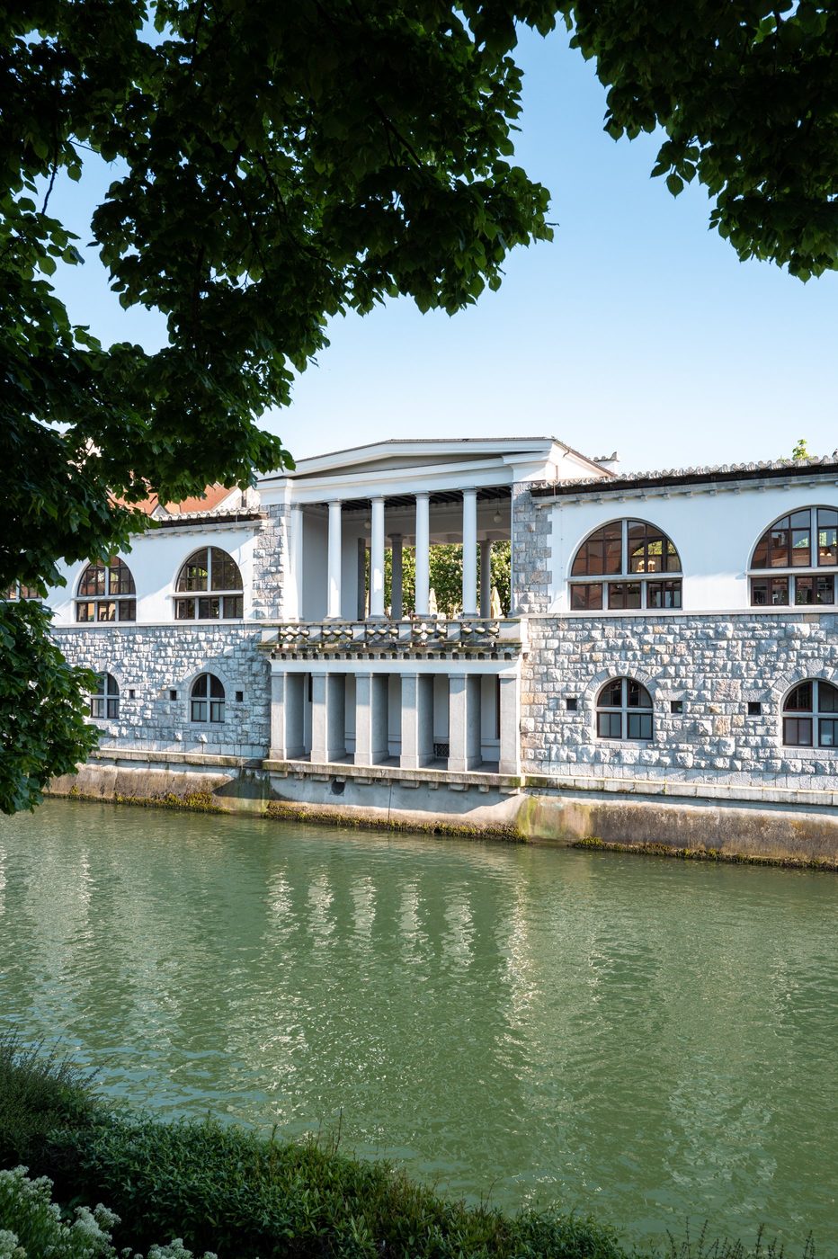 Neoclassical colonnade reflected in the waters of the river, Ljubljana