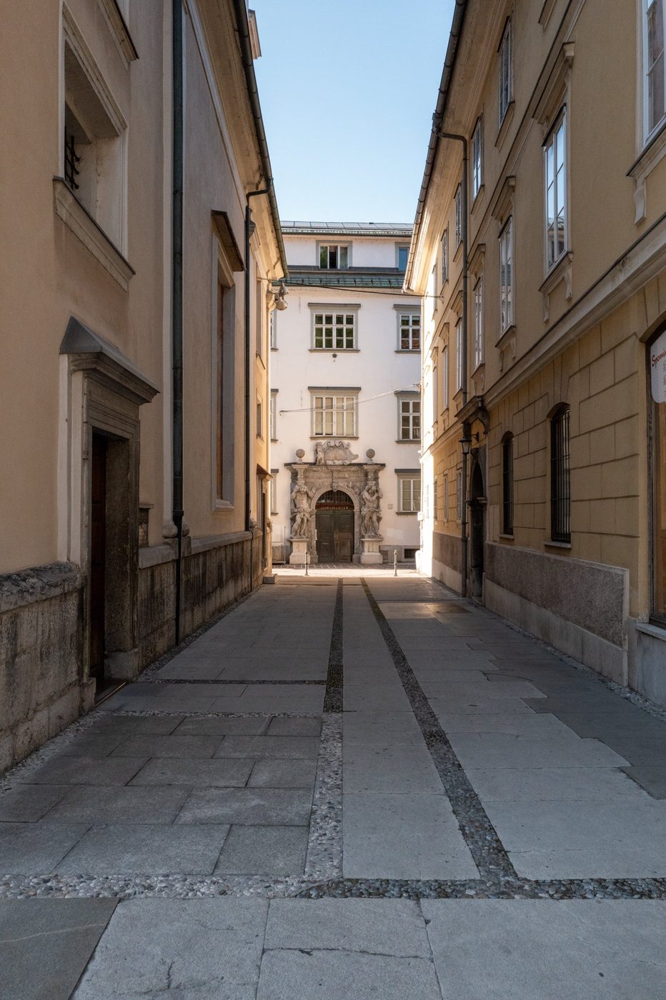 Quiet passage leading to a gateway adorned with statues, Ljubljana