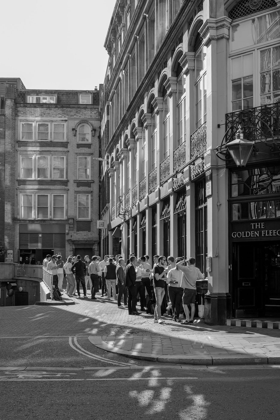 Crowd of colleagues enjoying the sun outside The Golden Fleece pub, London