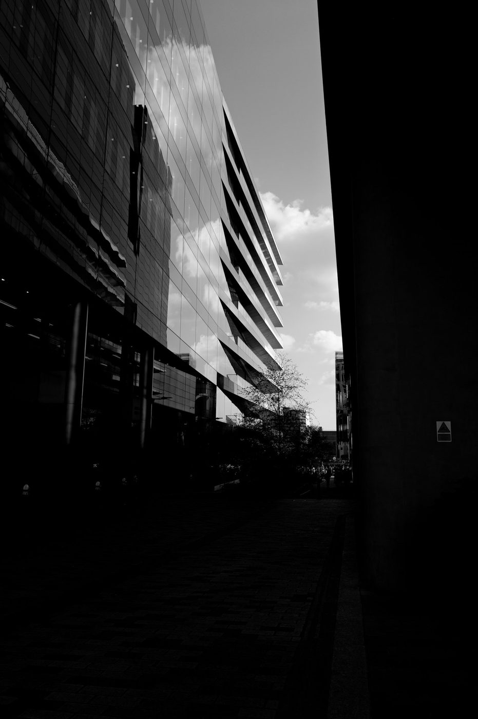 Dark alley framed by modern glass facades standing out against the sky, London
