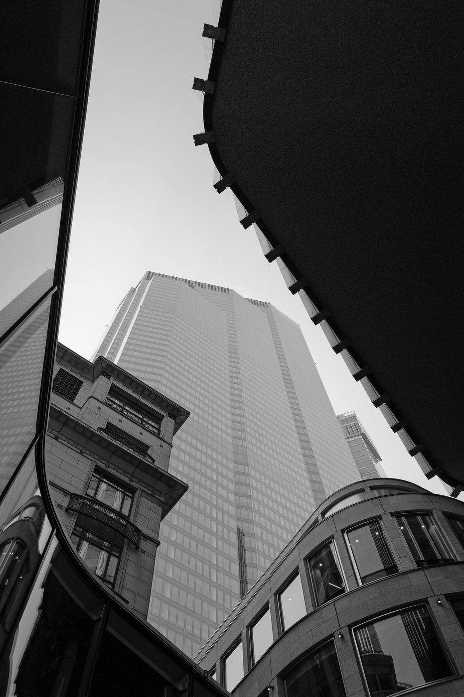 Abstract low-angle view between glass facades and the curves of an old building, London