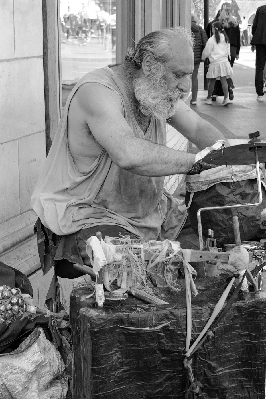 Bearded street musician playing handmade percussion and instruments, London