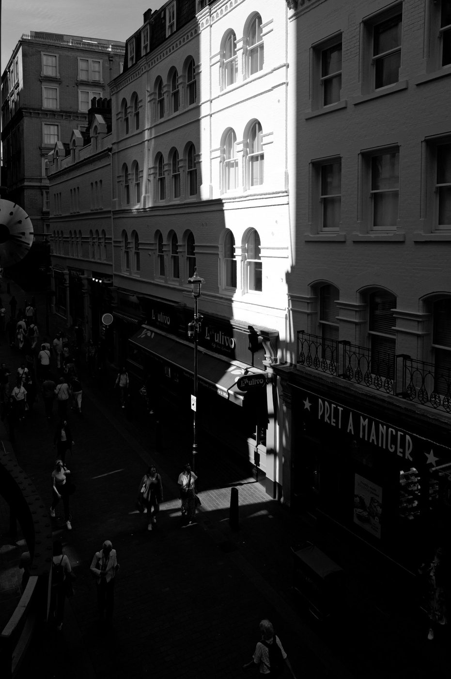 High-angle view of a shopping street lit at an angle by the sun, London