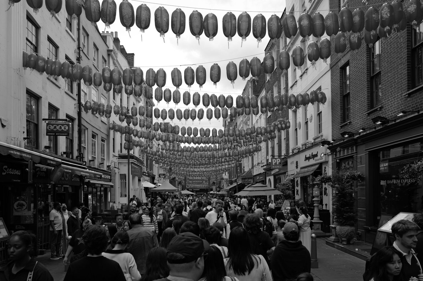 Rows of red lanterns hanging over a crowded Chinatown street, London