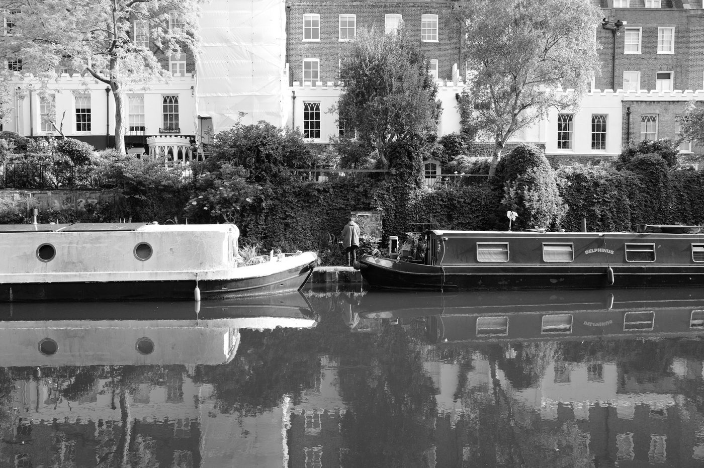 Two narrowboats facing each other on the canal, a lone figure on the towpath, London