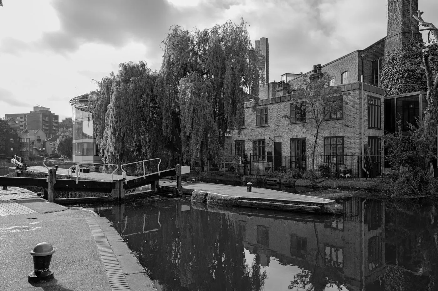 Écluse bordée d'un saule pleureur près d'anciens entrepôts réhabilités, Londres