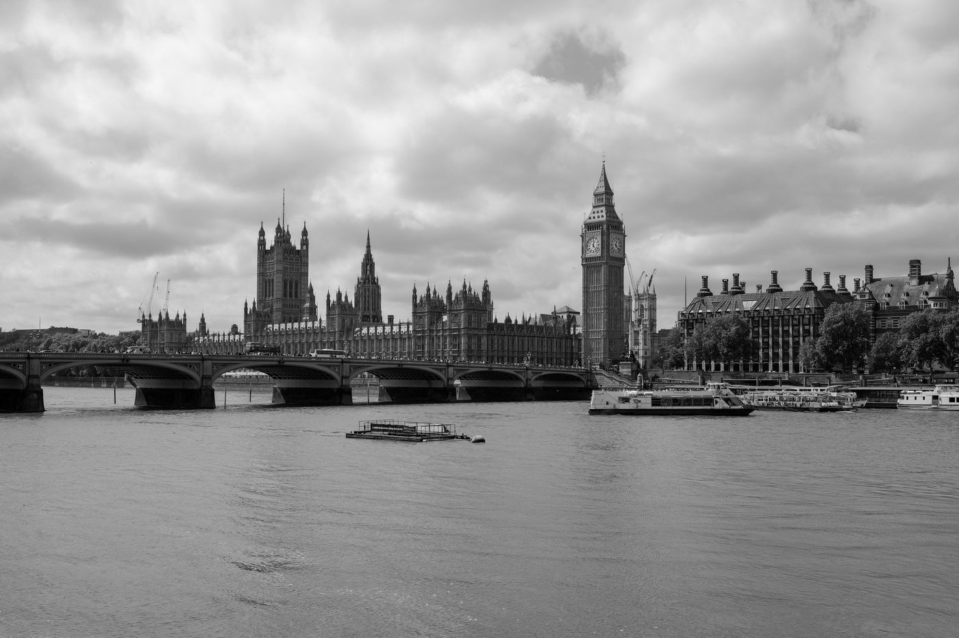Westminster Bridge and Parliament seen from the Thames, tourist boats moored, London