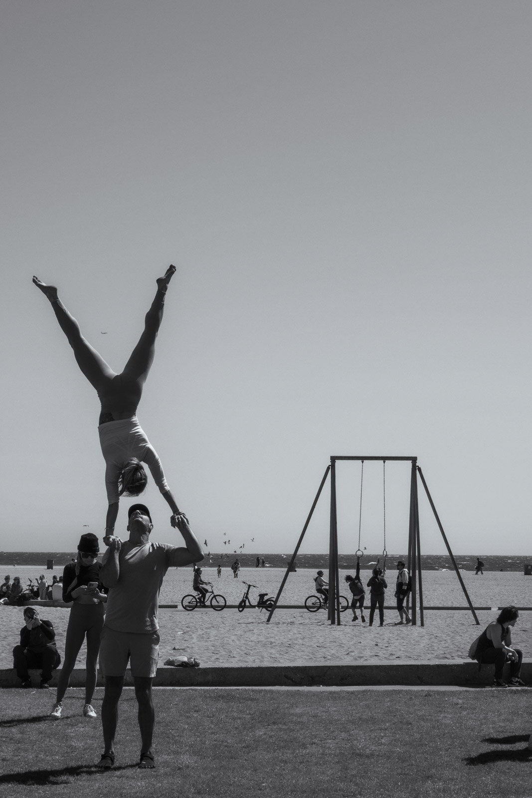 Acrobats balancing in a lift on the beach, Los Angeles