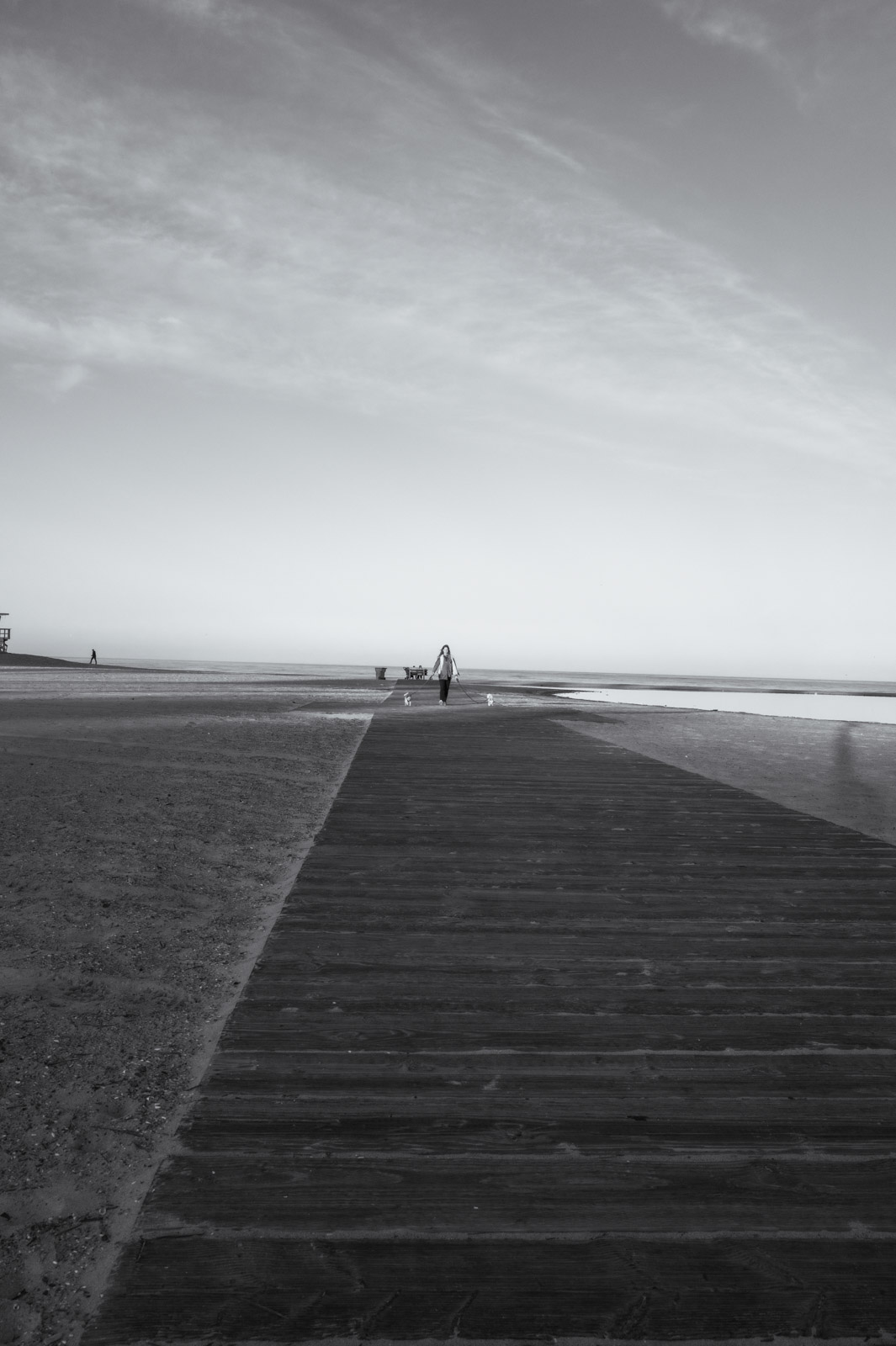 Solitary figure at the end of a wooden pier at dawn, Los Angeles
