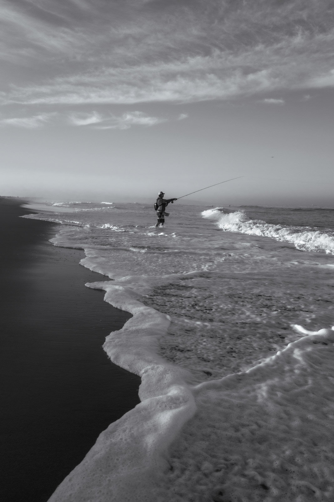 Silhouetted fisherman in the surf, Los Angeles