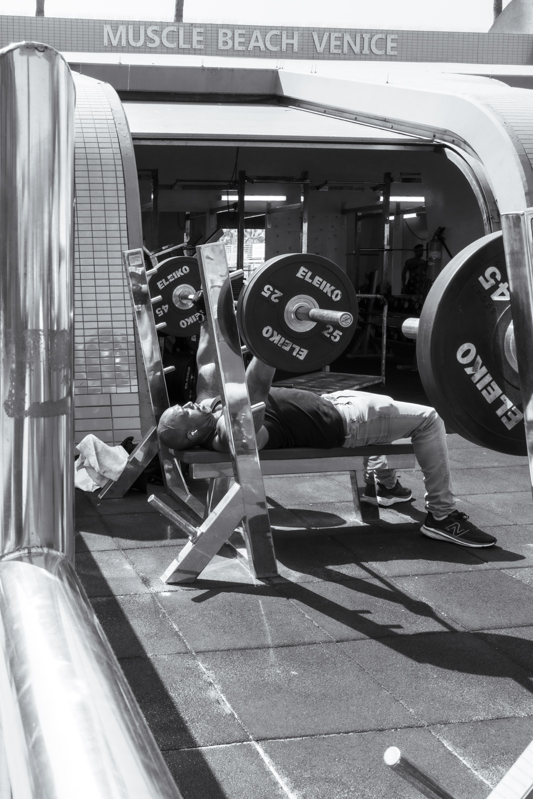 Man lifting weights at Muscle Beach Venice, Los Angeles