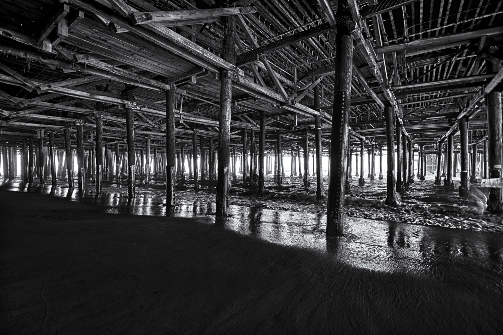 Underneath Santa Monica Pier, a receding perspective of wooden pilings, Los Angeles