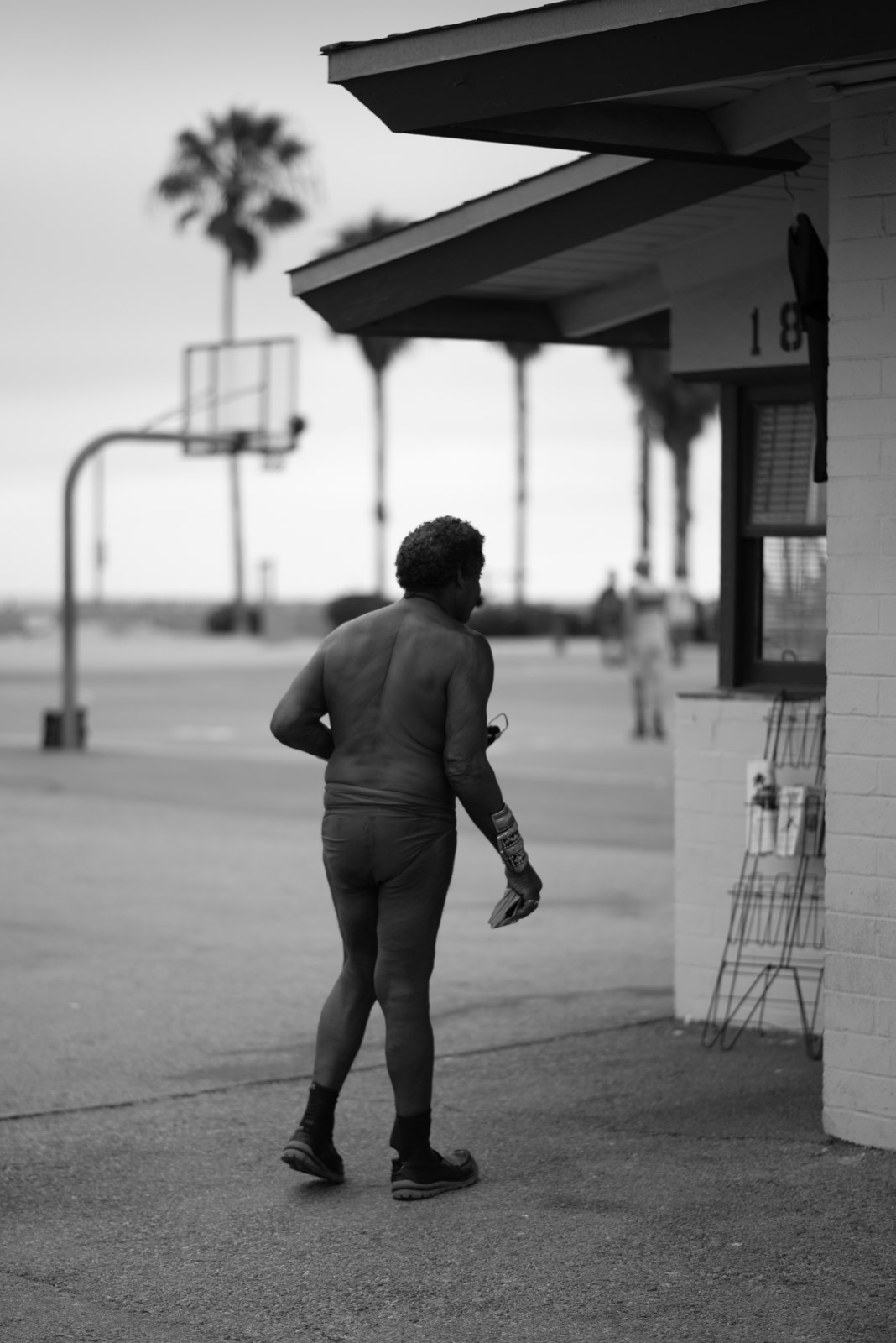 Man in athletic wear walking near a building at Muscle Beach, Los Angeles