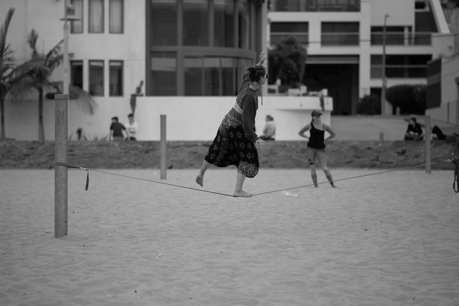 Beach paddle tennis game on a sand court between buildings, Los Angeles