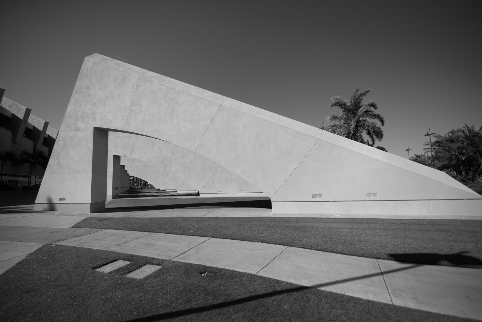 White concrete sculpture with curved lines, palm trees in the background, Los Angeles