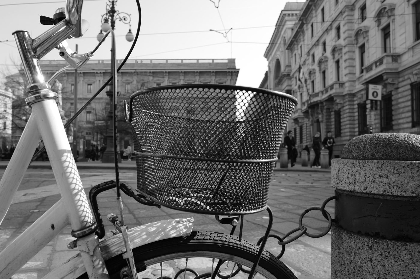 Close-up of the handlebars and wire basket of a vintage bicycle on the square, Milan