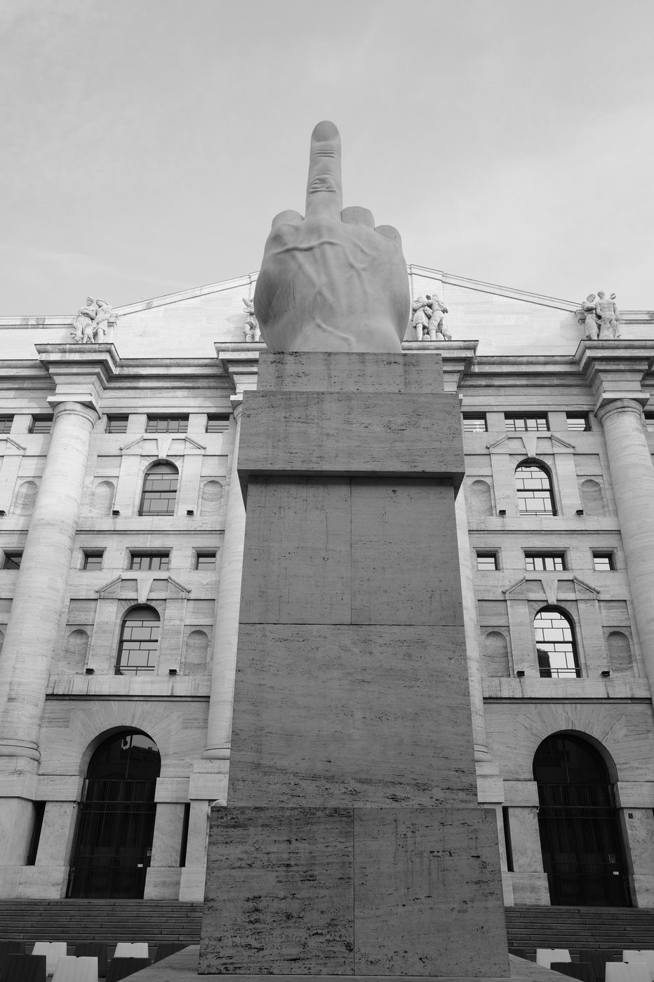 Monumental sculpture of a raised middle finger in front of the Palazzo Mezzanotte, Milan