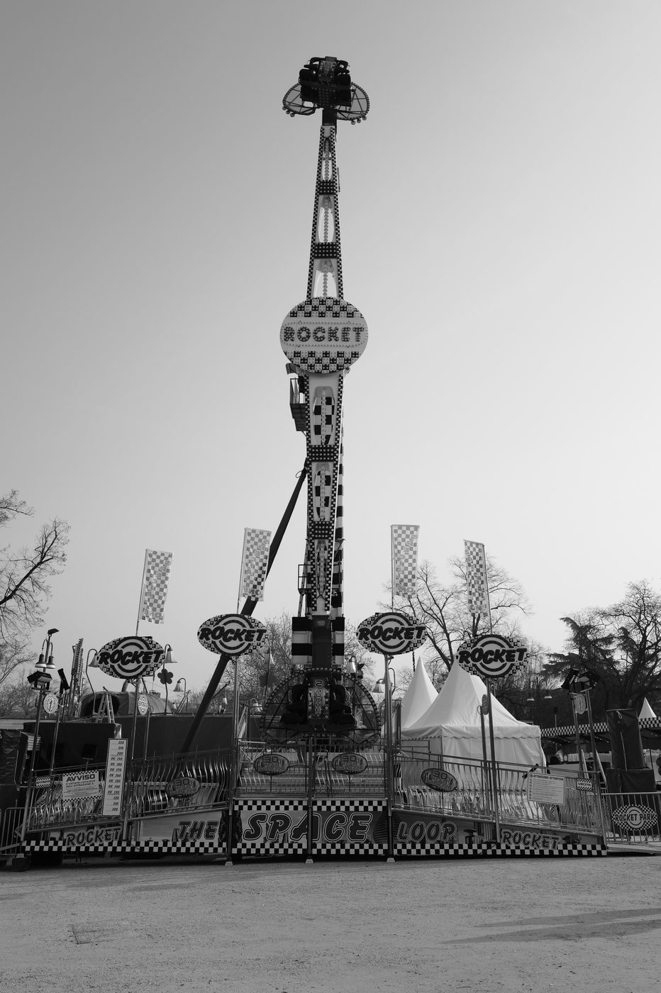 Rocket fairground ride rising high above an amusement park, Milan