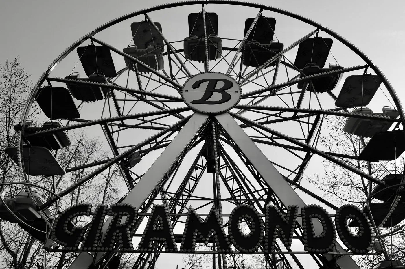 Grande roue Giramondo vue de dessous entre les arbres dénudés, lettres illuminées, Milan