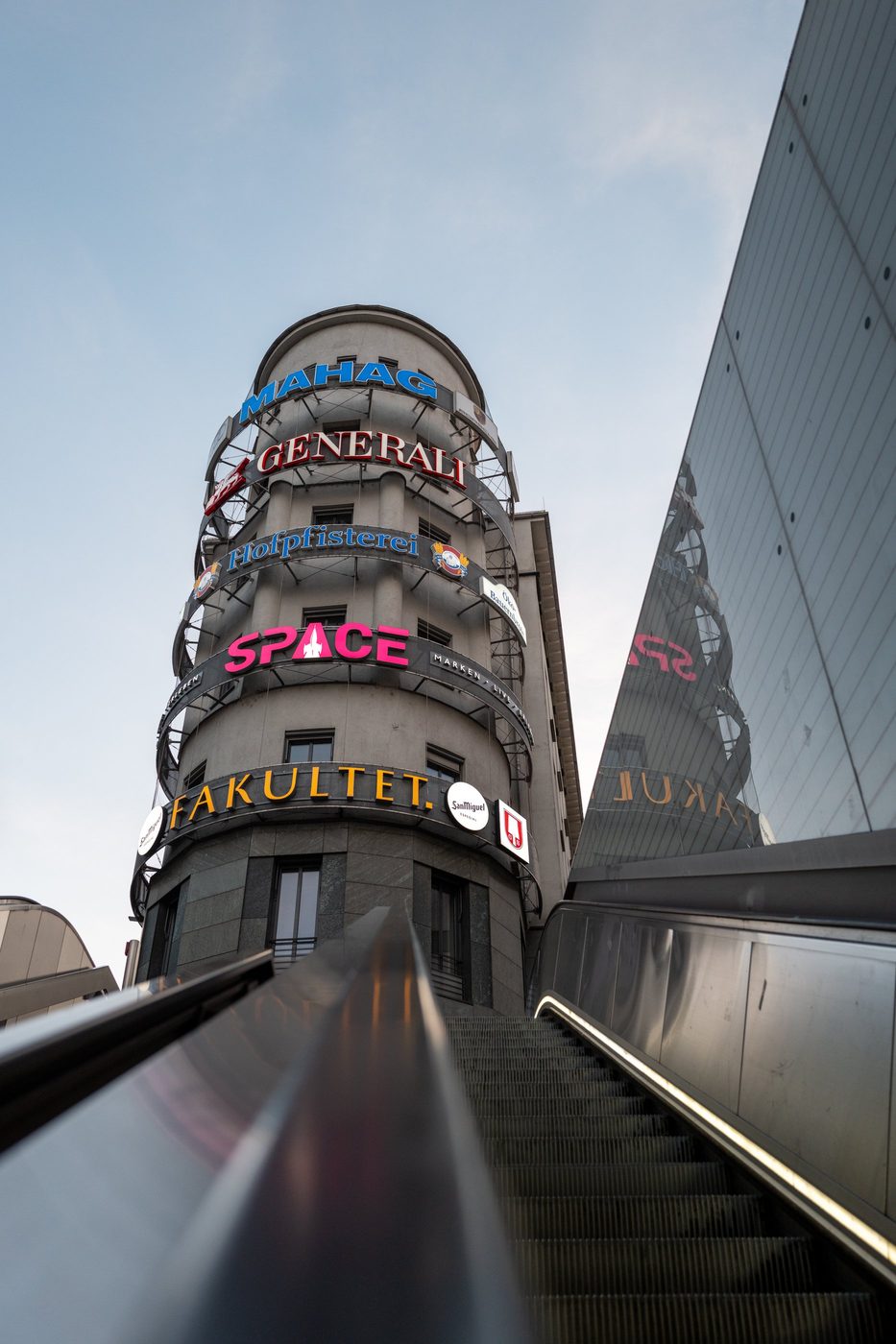 Low-angle view of a building covered in overlapping commercial signs, Munich