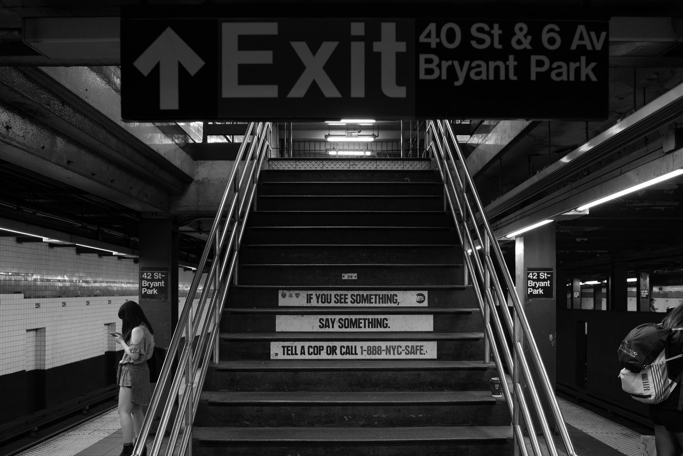 Subway station stairway beneath an illuminated exit sign, New York