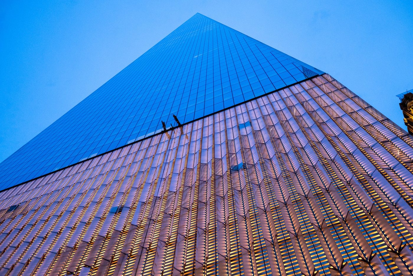 Low-angle view of a skyscraper's glass spire at dusk, New York