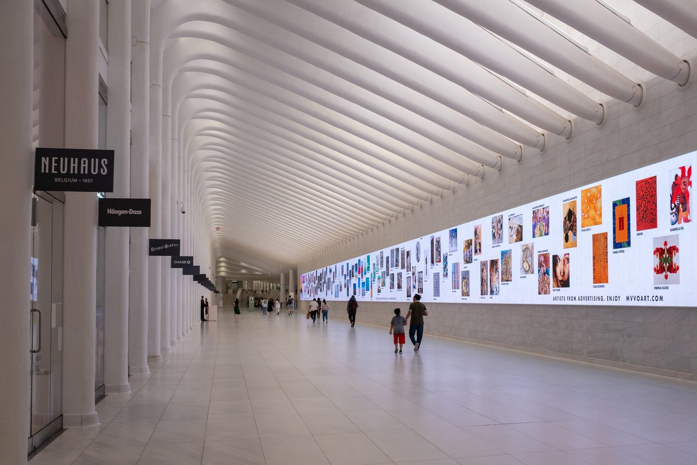 Vaulted gallery of the Oculus lined with shops and a digital art wall, New York