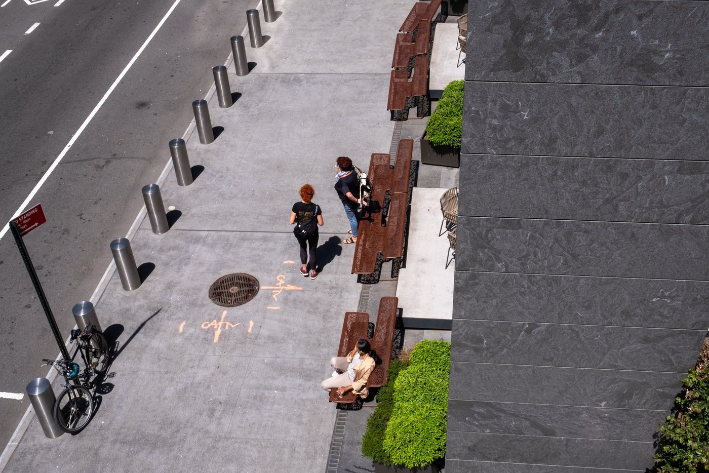 Overhead view of a sidewalk lined with benches and greenery, New York