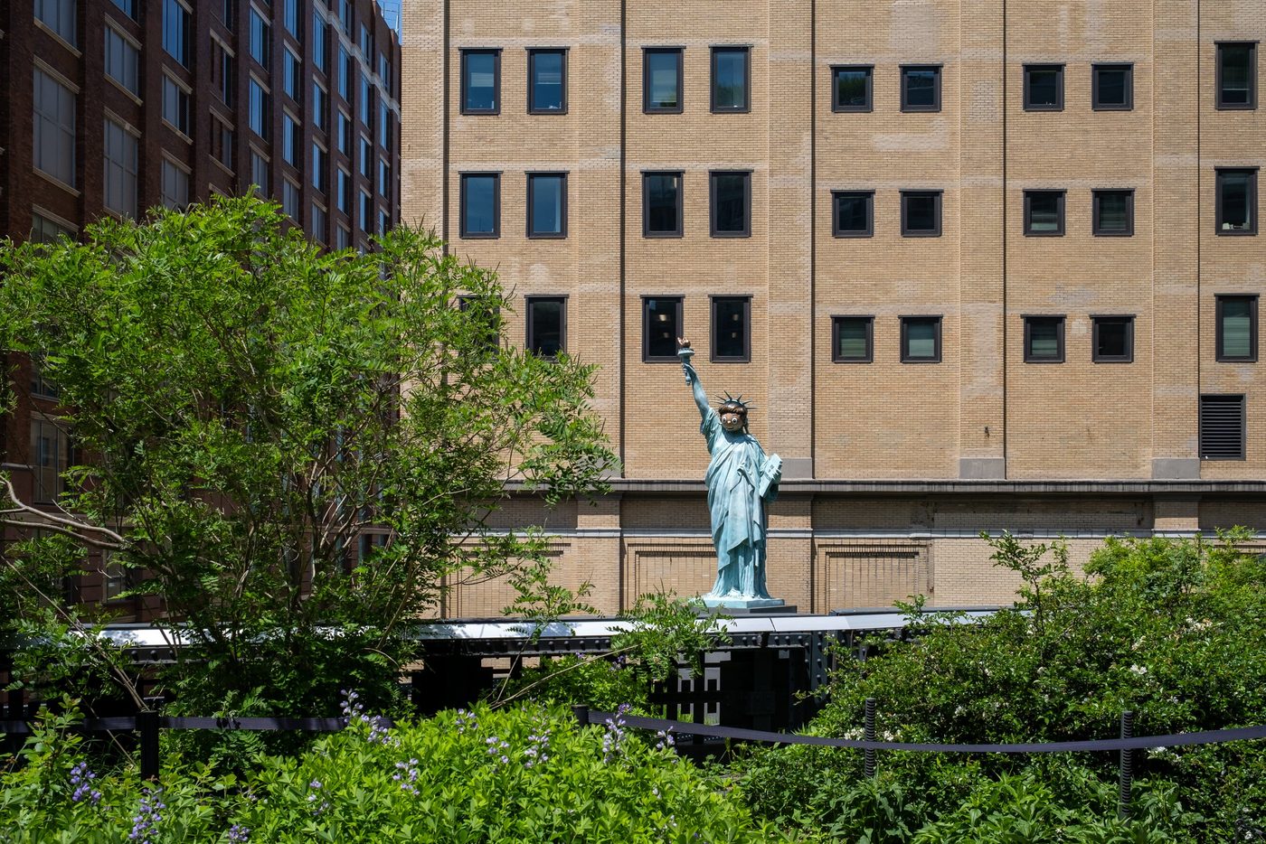 Miniature replica of the Statue of Liberty surrounded by greenery on the High Line, New York