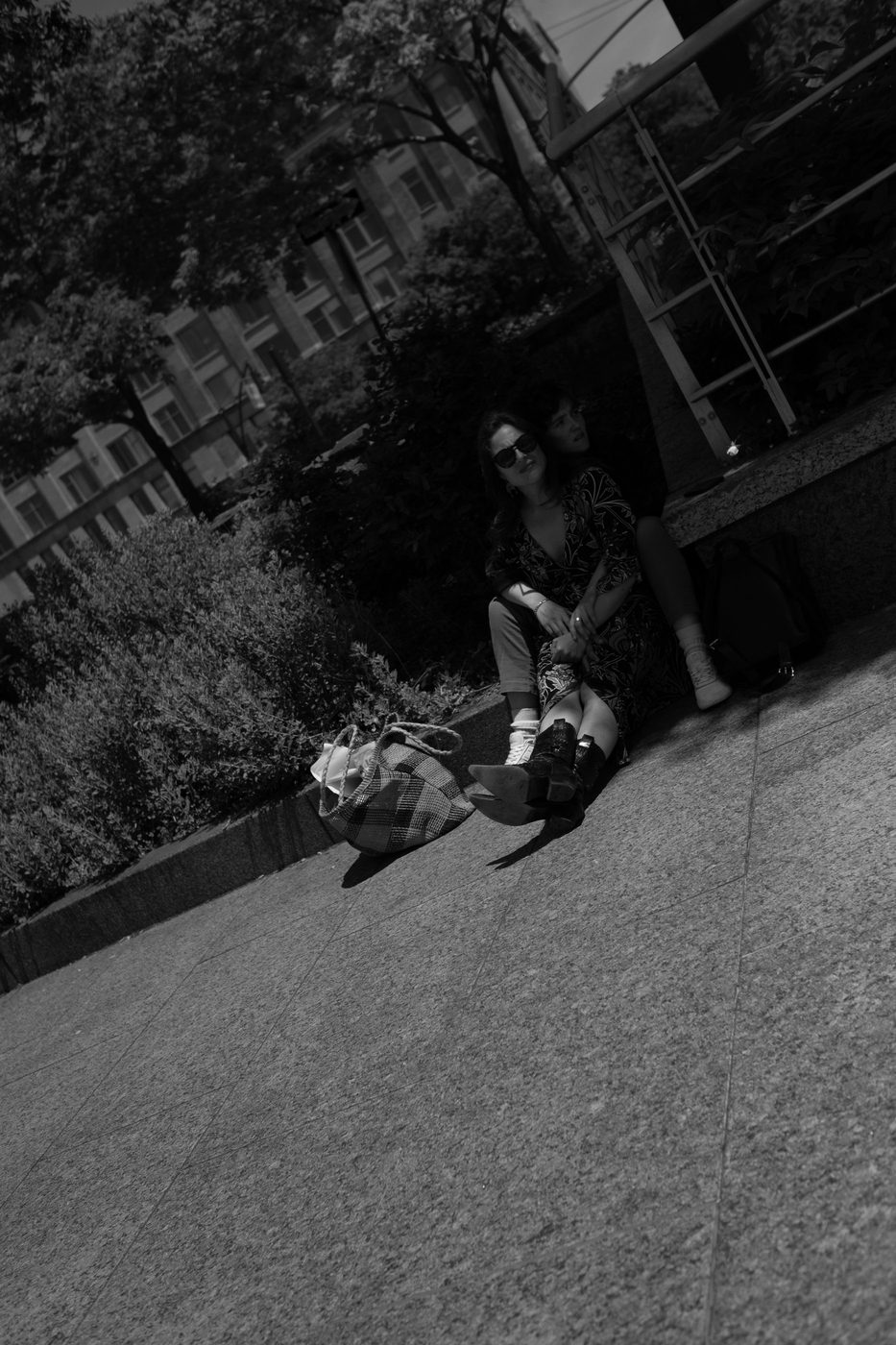 Two women sitting side by side in the shade of a wall, low-angle view, New York