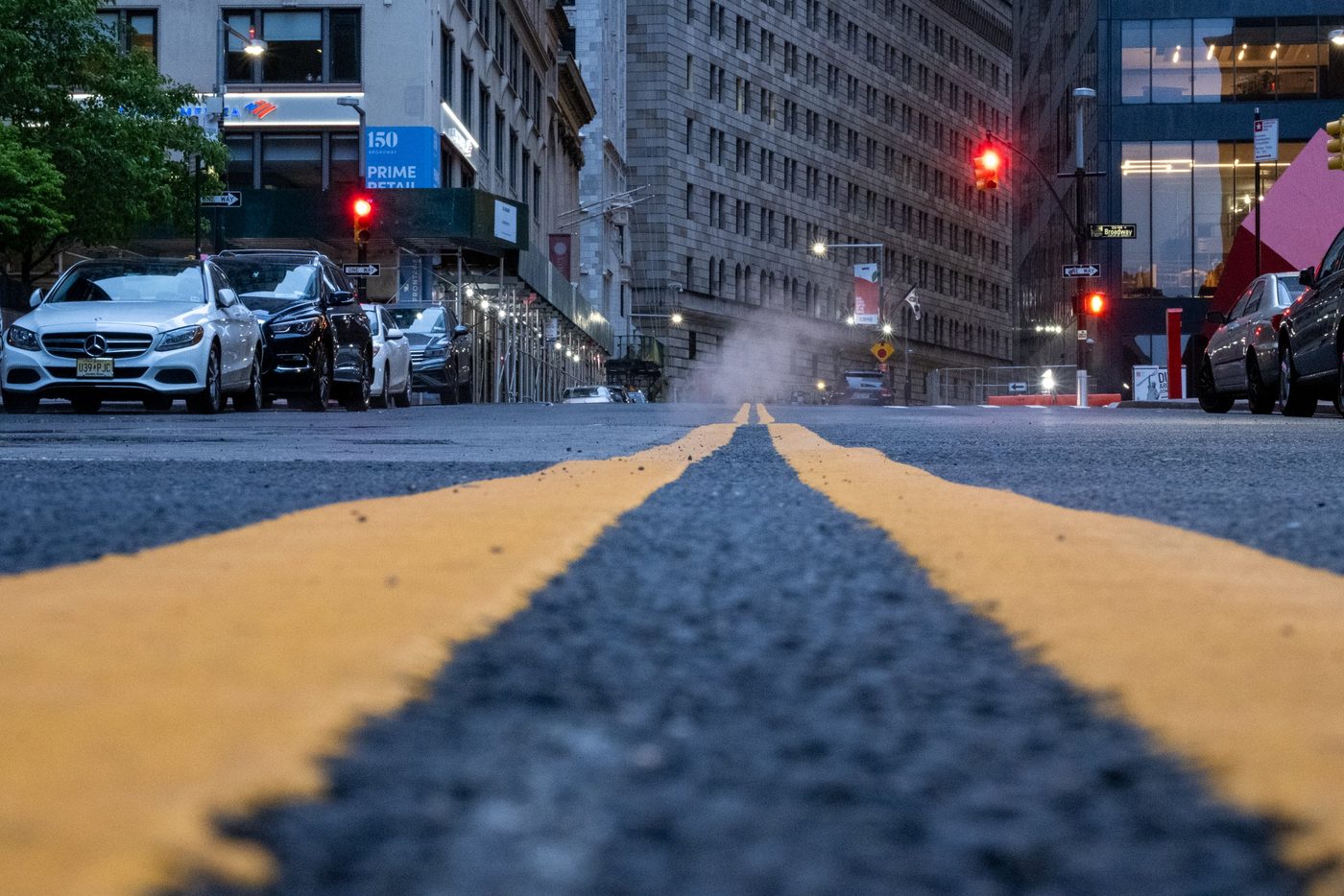 Yellow line on the ground leading toward a red light and rising steam, New York