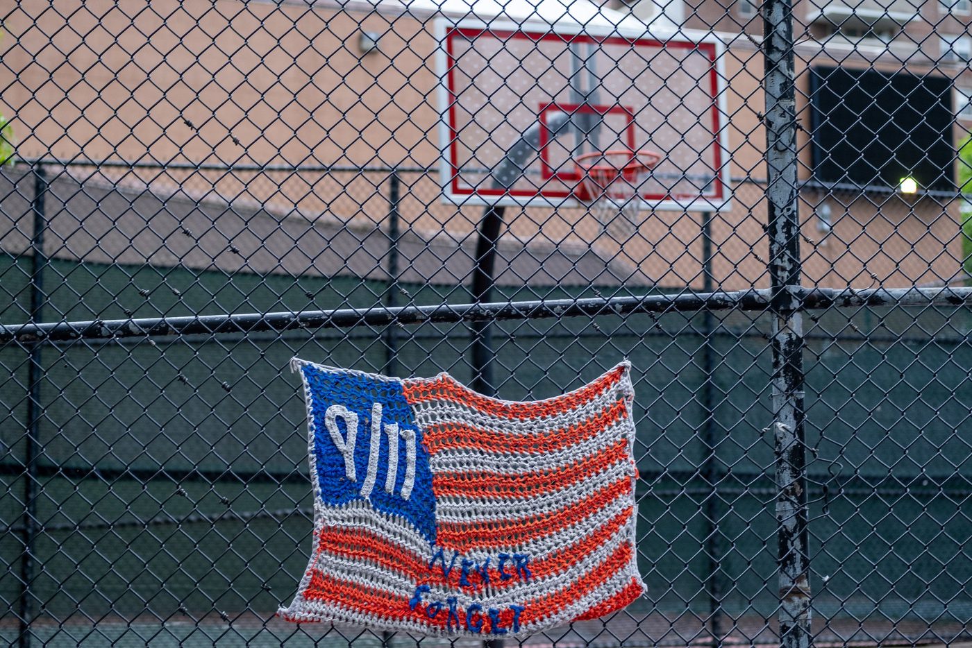 Knitted flag honoring 9/11 hanging on a chain-link fence, New York