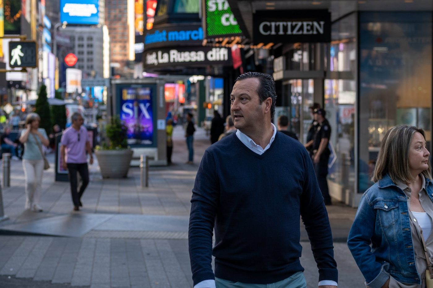 Man walking through Times Square beneath the illuminated signs, New York