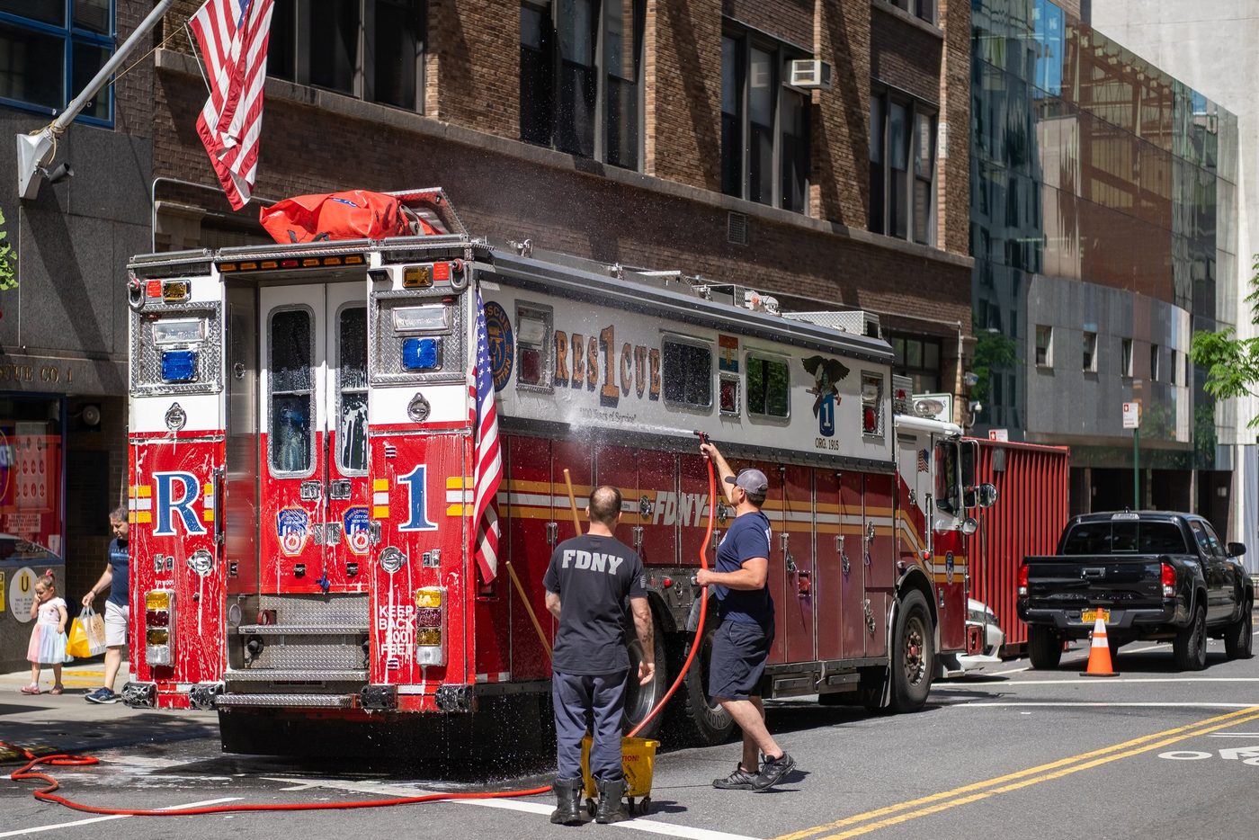 FDNY firefighters washing their rescue truck in the street, New York