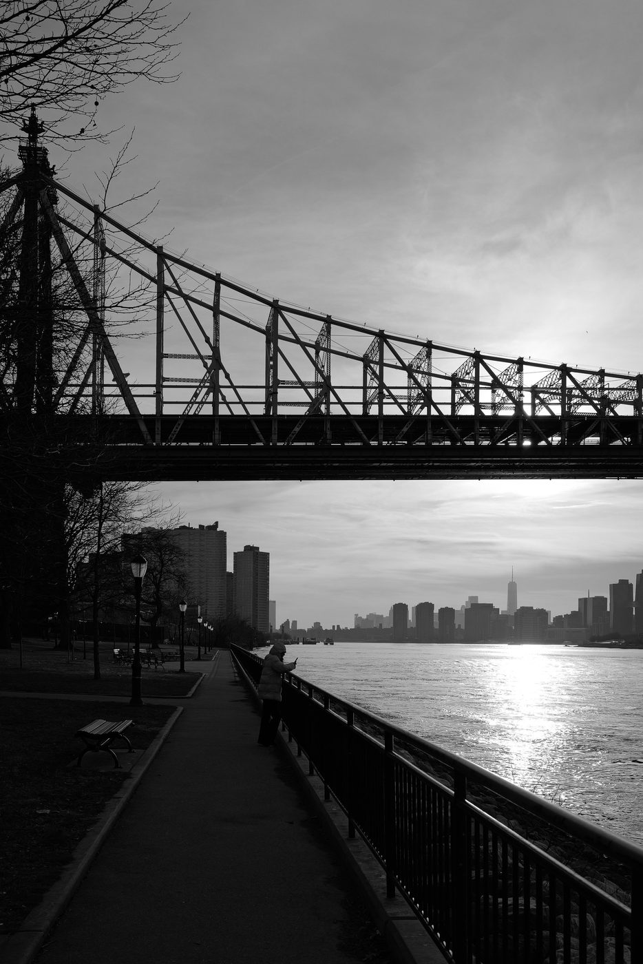 Silhouette of a metal bridge over the river at sunset, New York