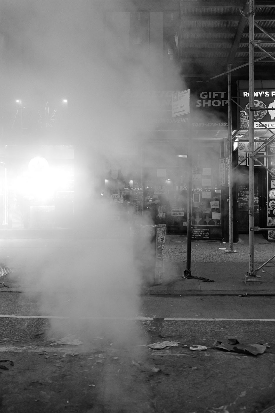 Dense steam engulfing a street in front of a souvenir shop, New York