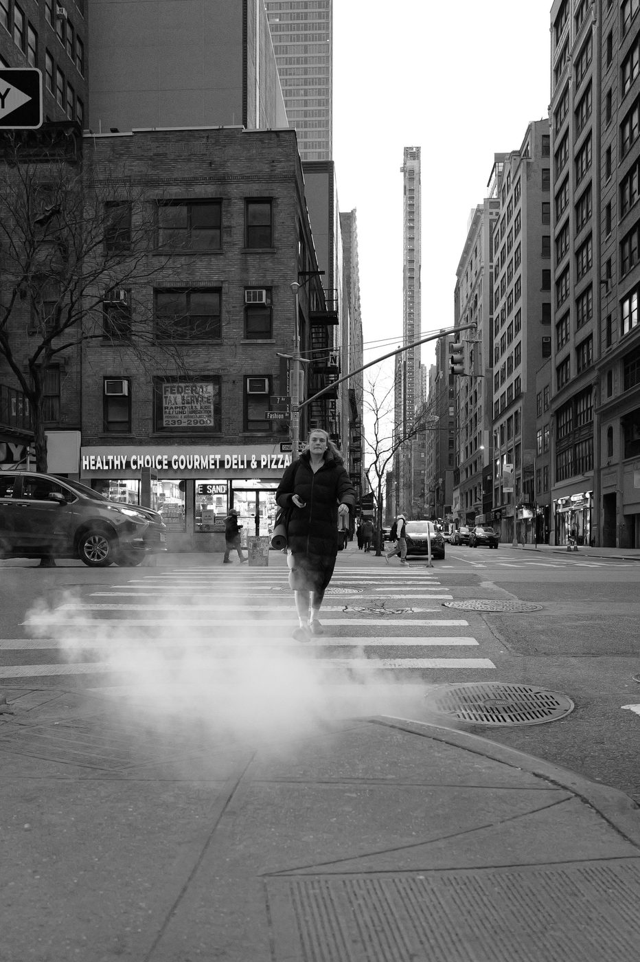 Woman crossing a crosswalk wrapped in steam, New York
