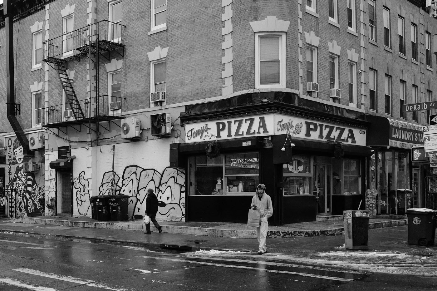 Street corner with the Tony's Pizza sign and a mural, New York