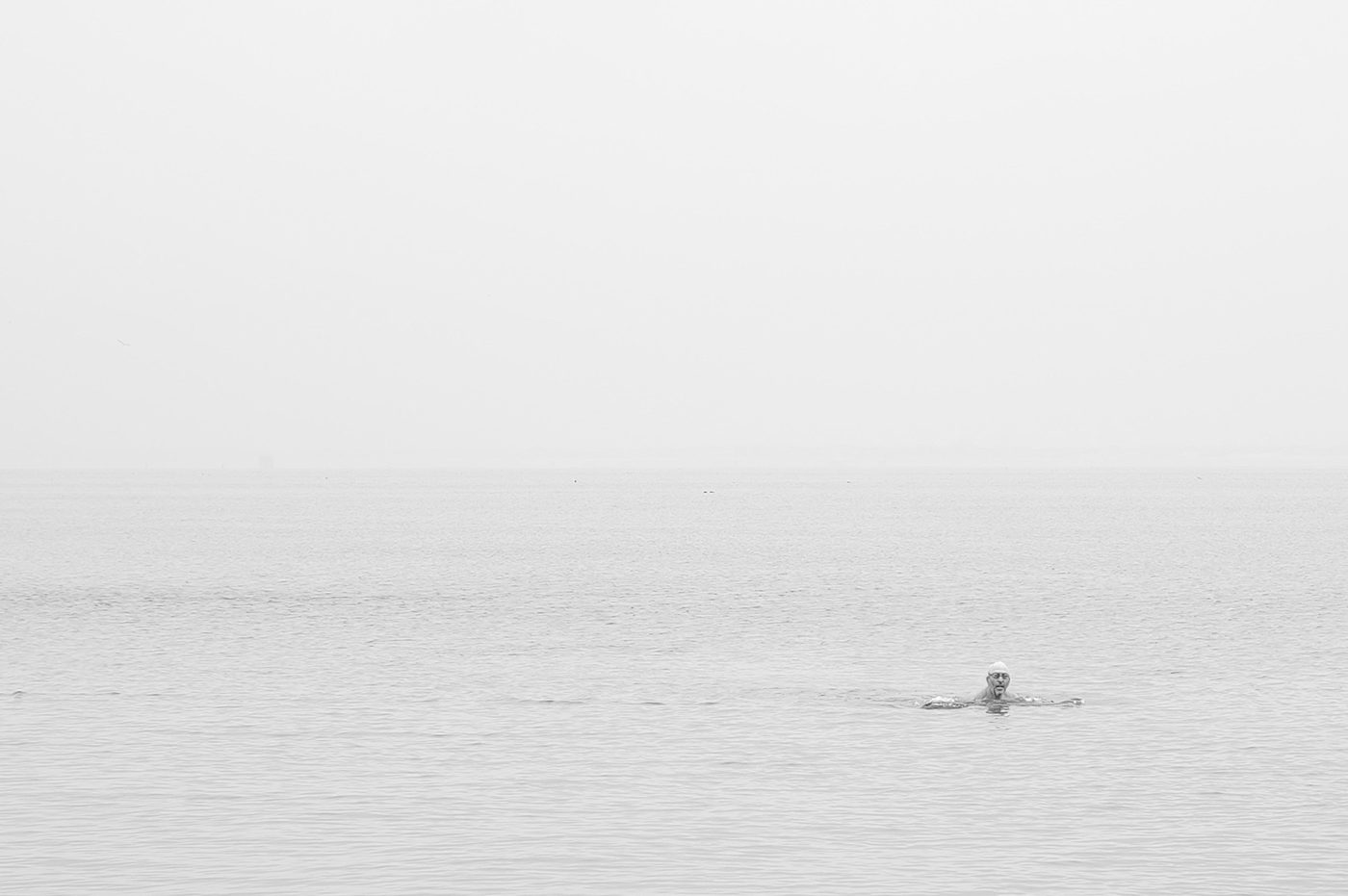 A swimmer's head emerging from a milky, misty sea, New York