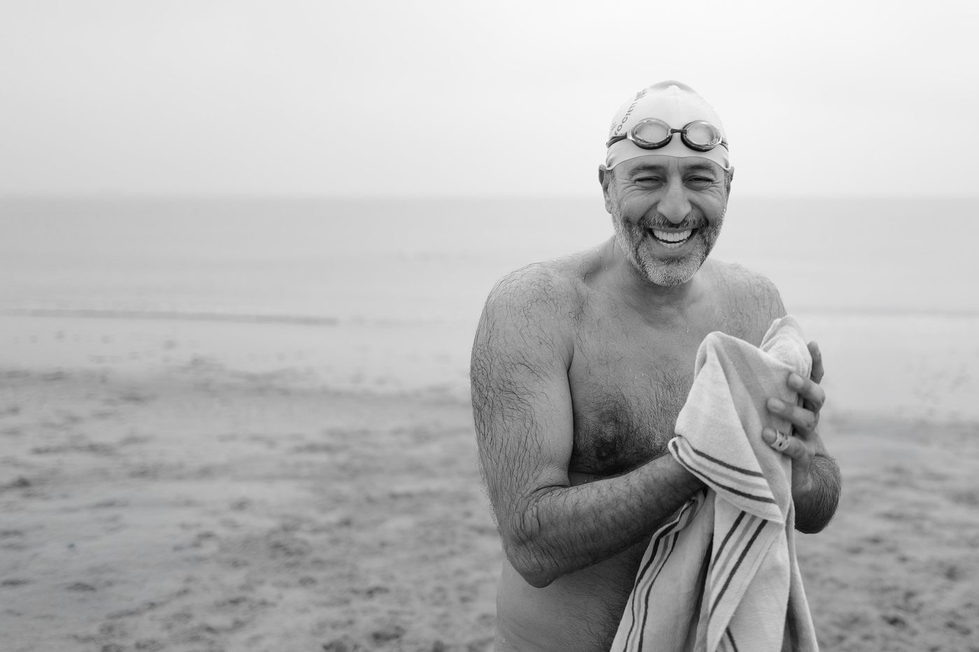 Smiling portrait of a swimmer in a swim cap and goggles, New York