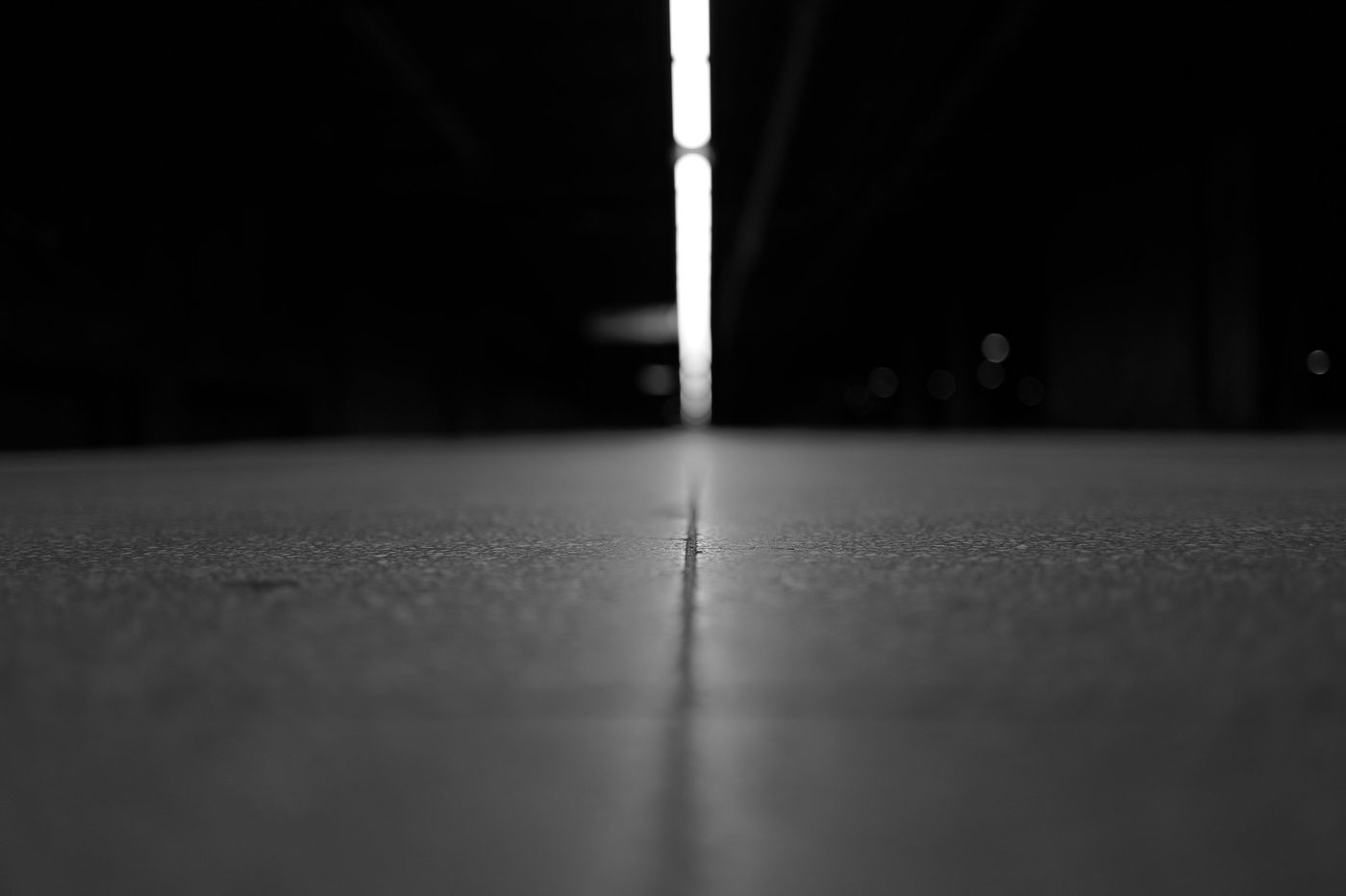 Perspective of a dark platform leading toward a band of light, New York