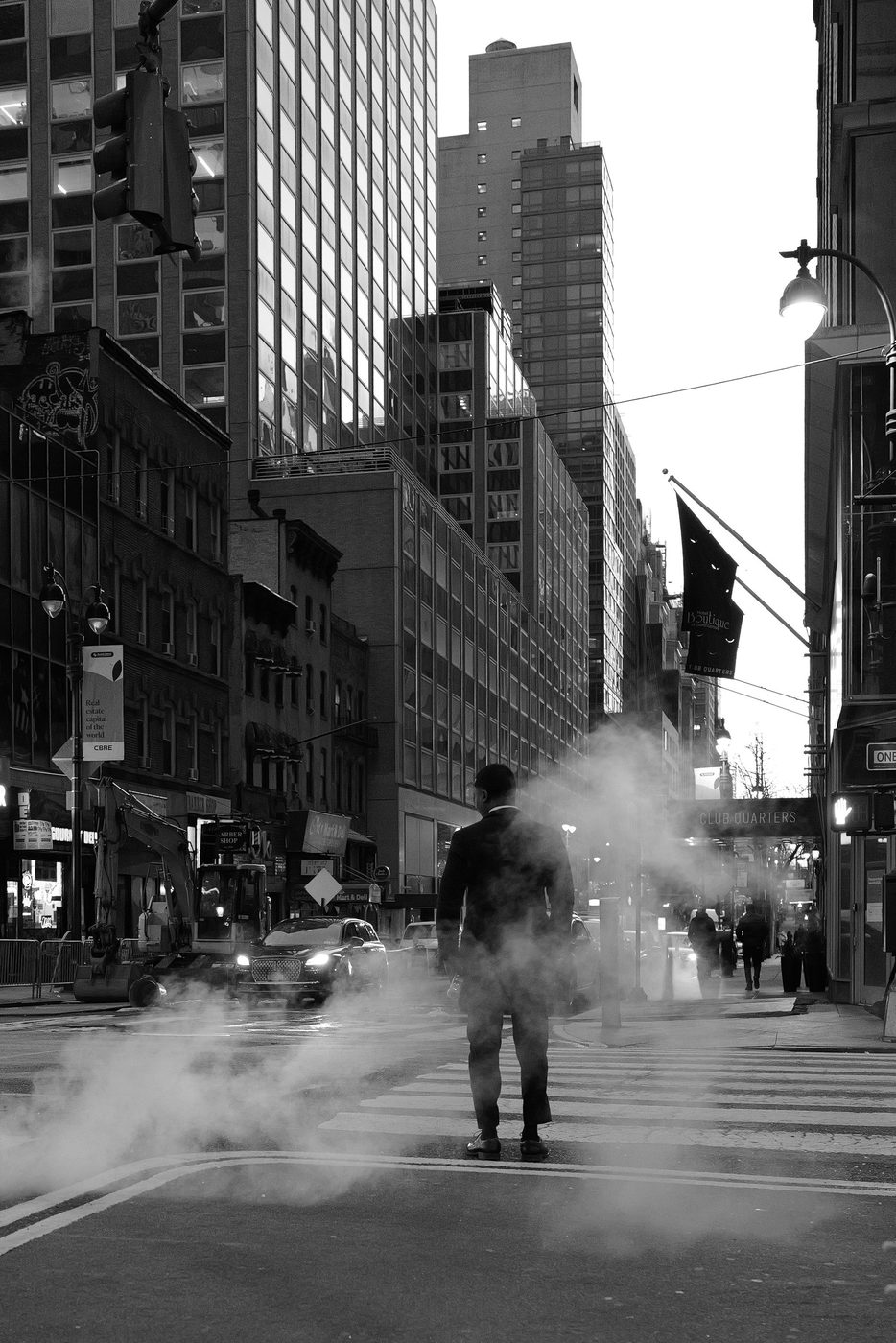 Man in a suit crossing the street through a cloud of steam, New York
