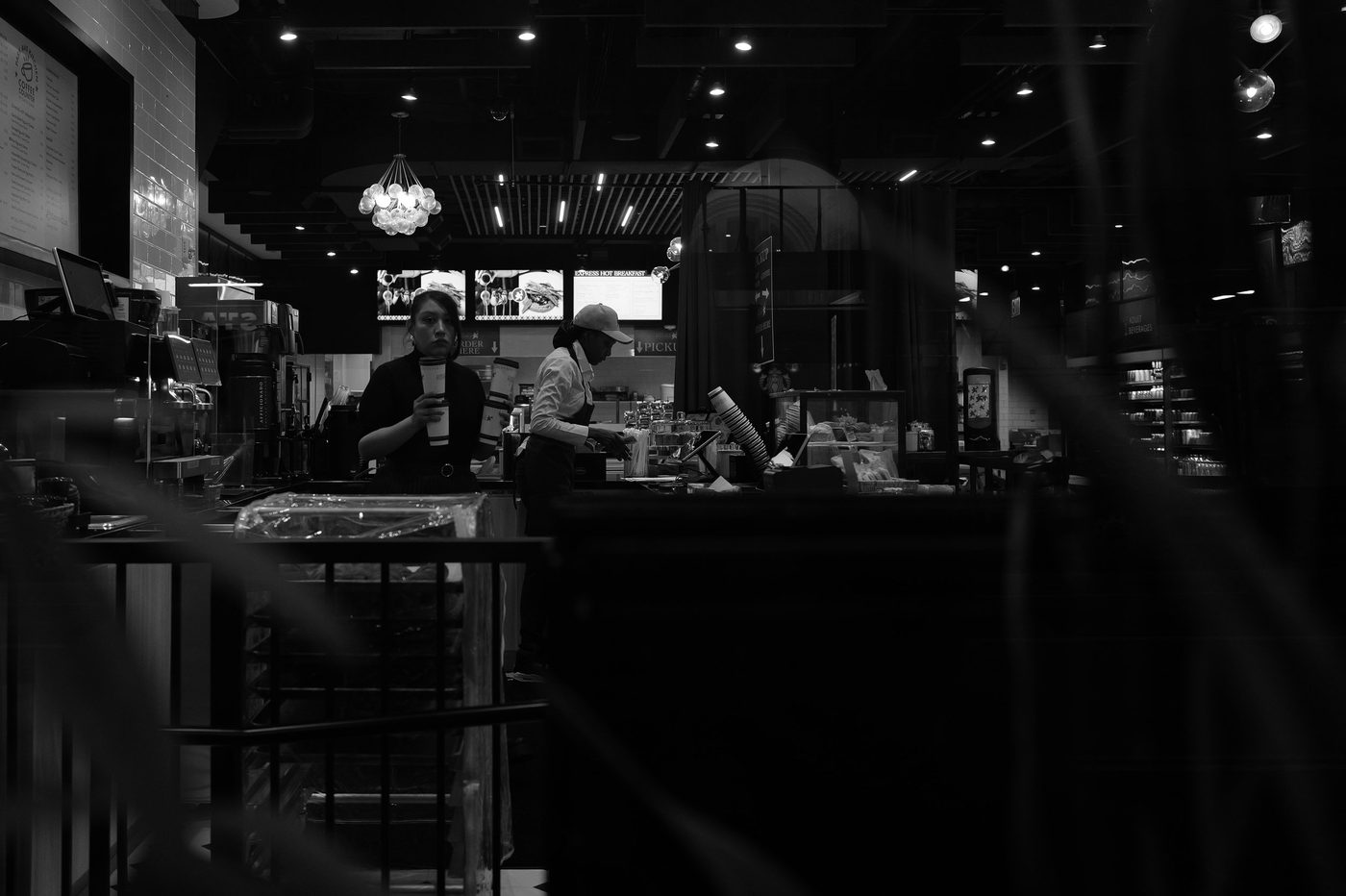 Customer and barista in a dimly lit cafe, New York