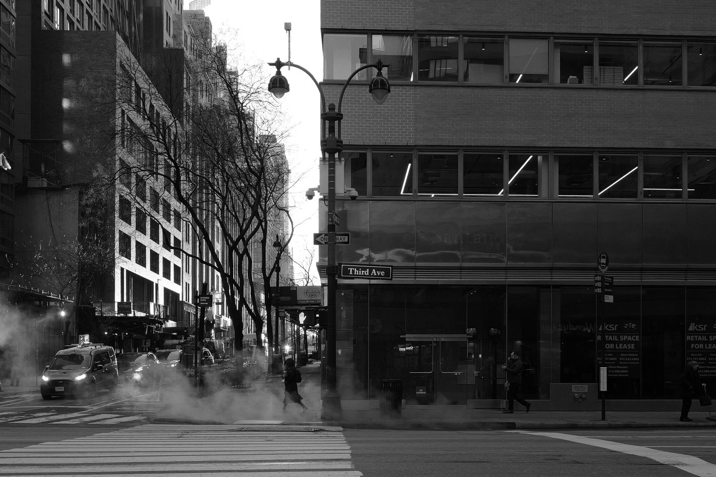 Woman crossing the street near the Third Avenue sign, New York