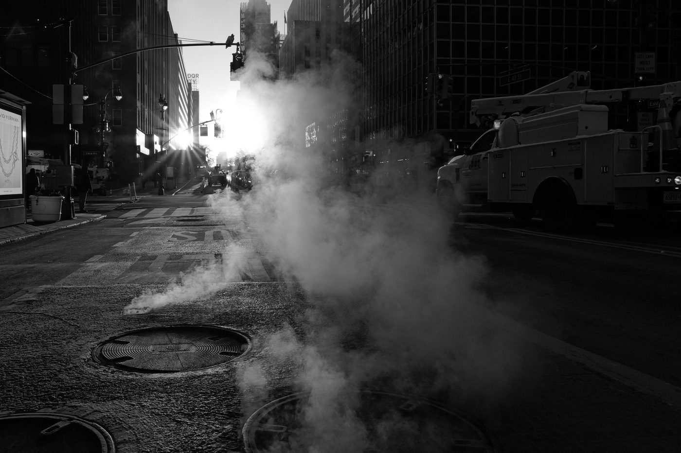 Steam backlit by the rising sun between the buildings, New York