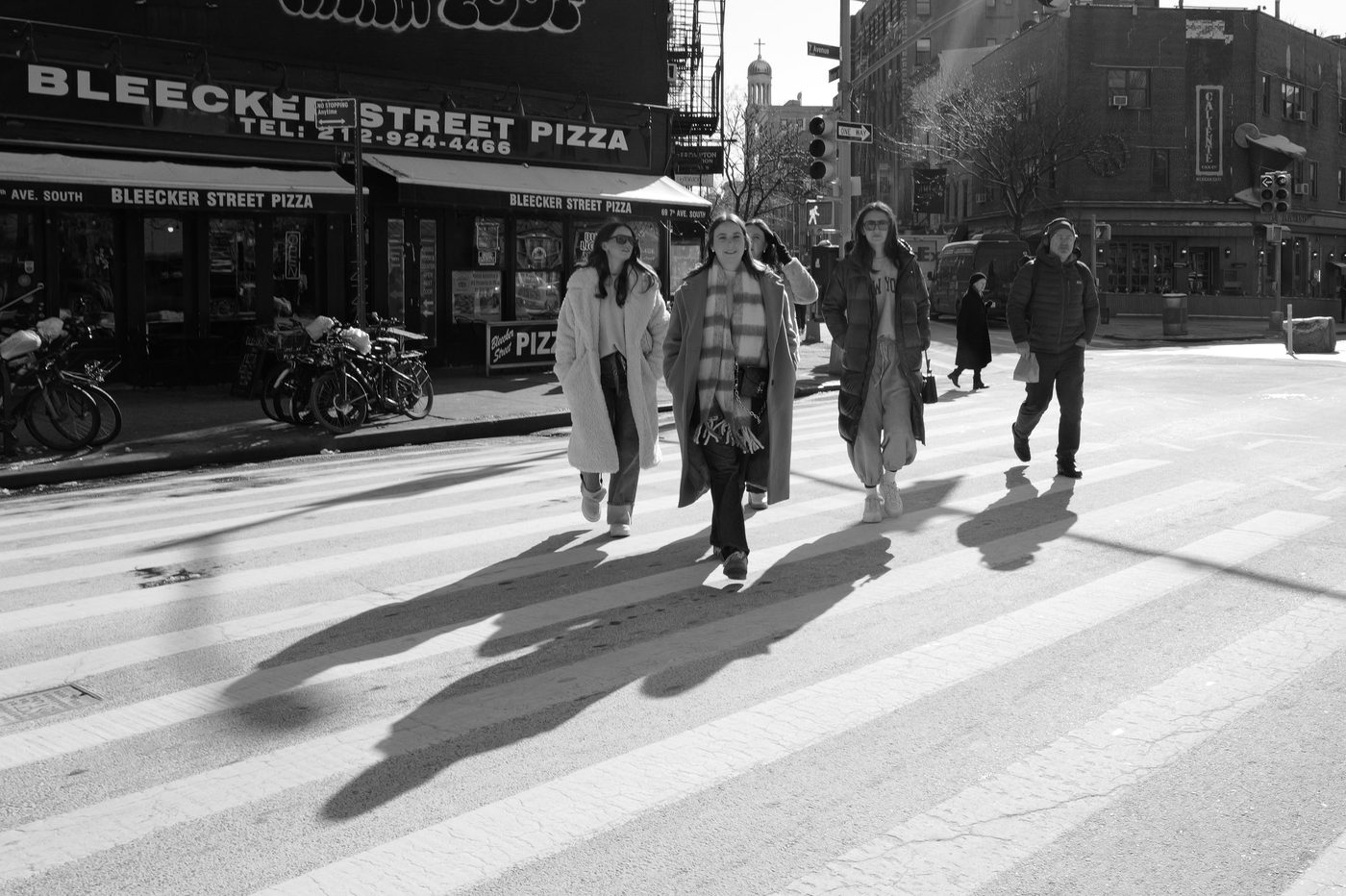 Group of friends crossing the street in front of Bleecker Street Pizza, New York