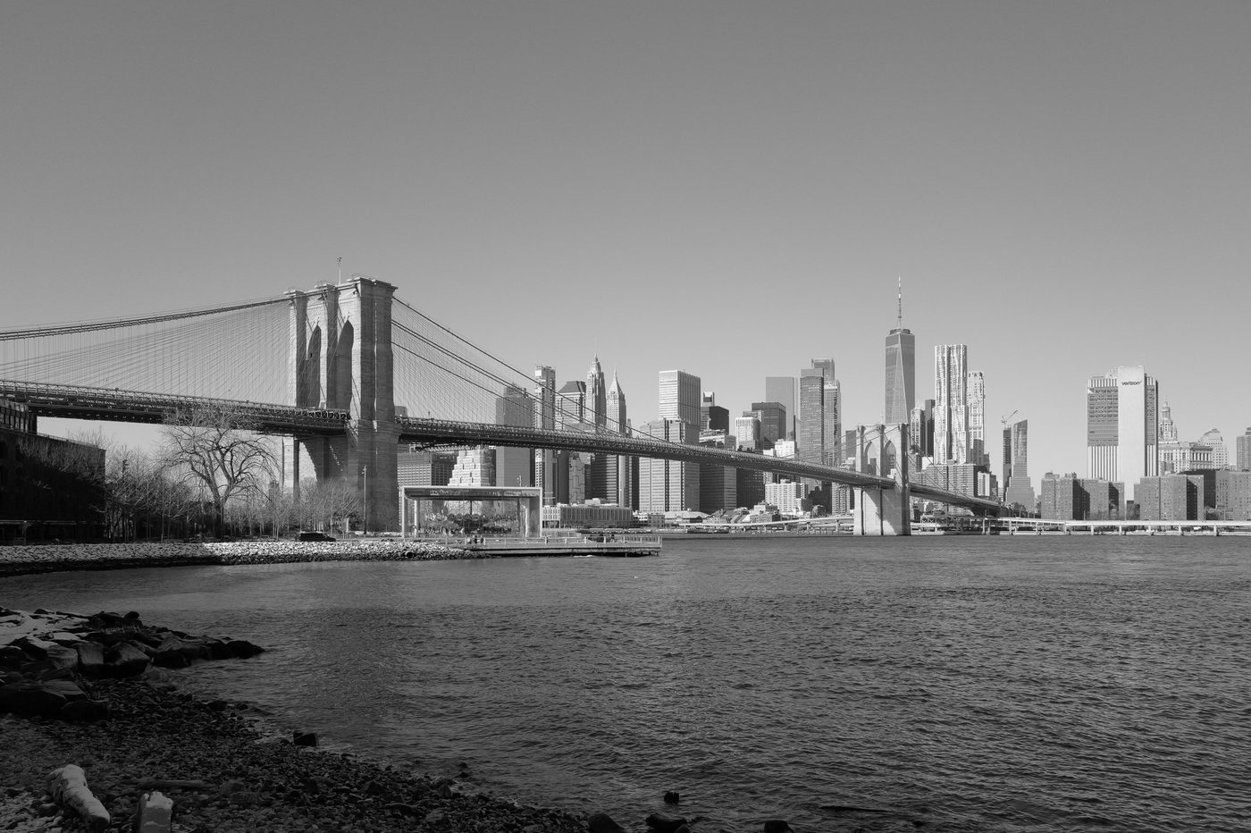 Brooklyn Bridge and Lower Manhattan skyscrapers under a clear sky, New York